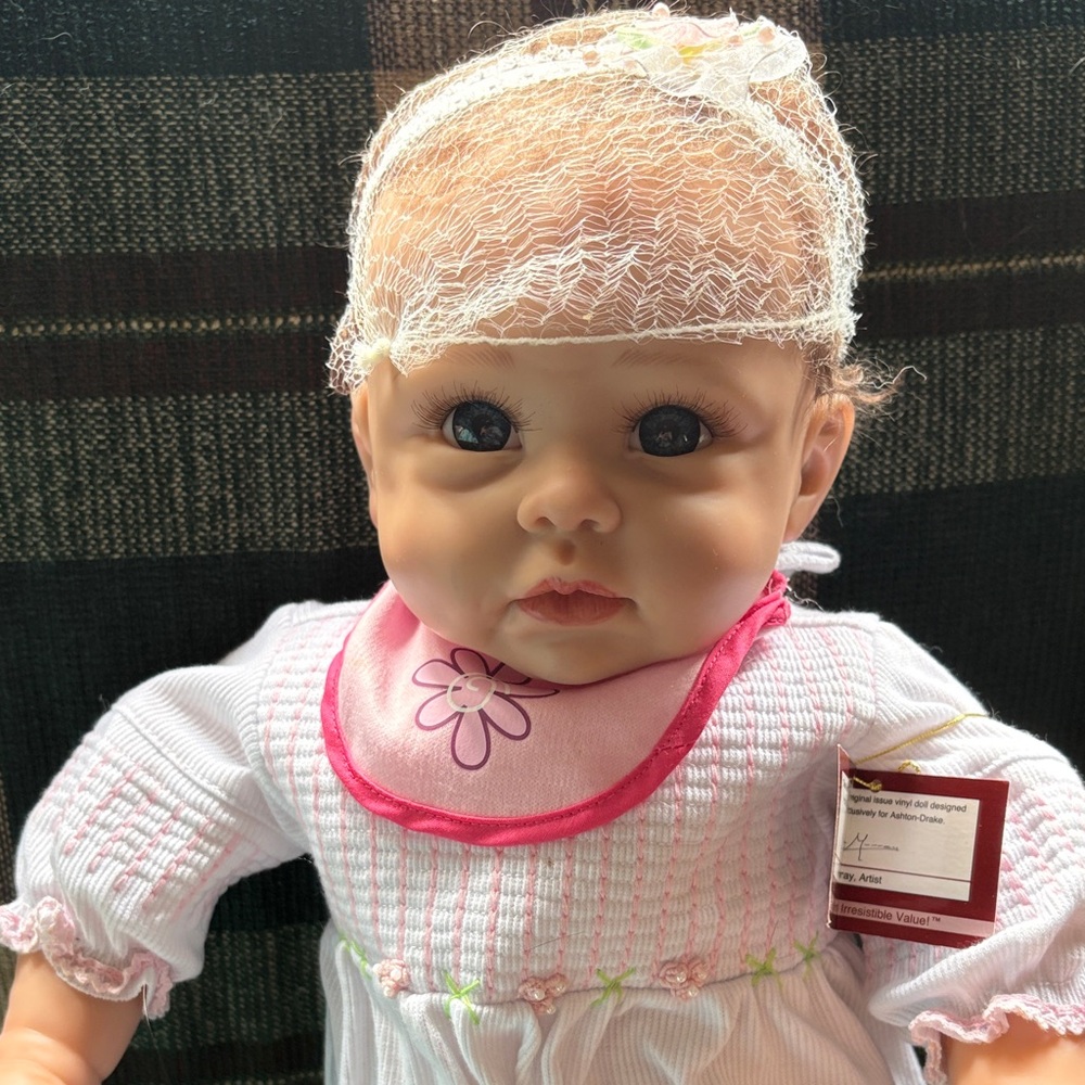 Charming Baby Doll with Pink Bib and White Dress